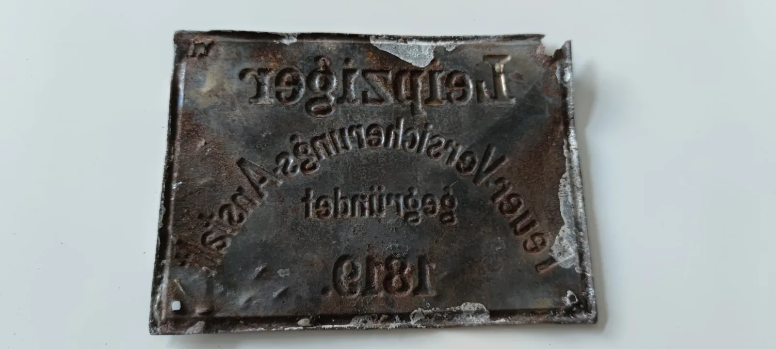 Tabliczka ubezpieczyciela od ognia „Leipziger Feuer-Versicherungs-Anstalt”, tego samego, co w akcie hipotecznym z 1910 r. (sfotografowana od rewersu)